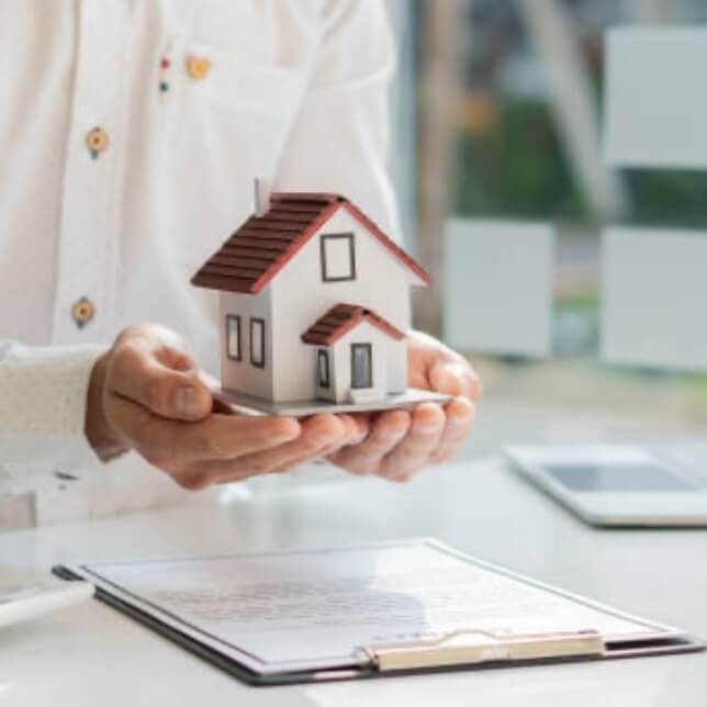 書類と家の模型を大切に守る手