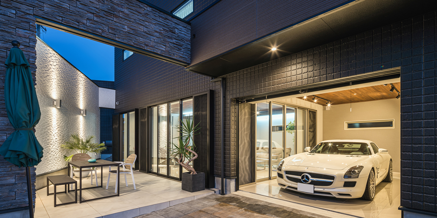 愛車を眺めるガレージと、中庭テラスのある家