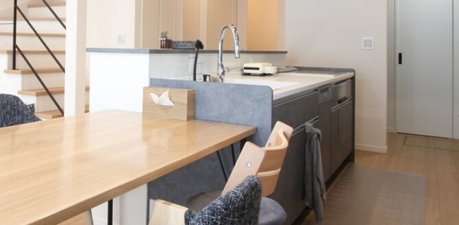 オープンキッチンで一緒に料理を楽しむ若い夫婦