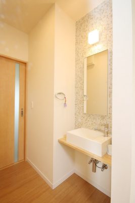 大きな鏡とタイルの壁面がおしゃれな手洗い場