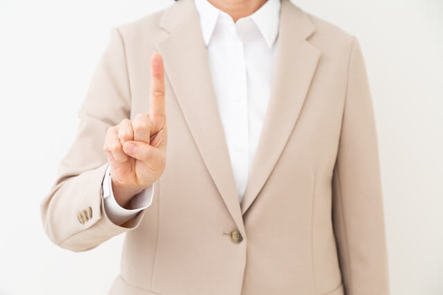 人差し指を立てる女性