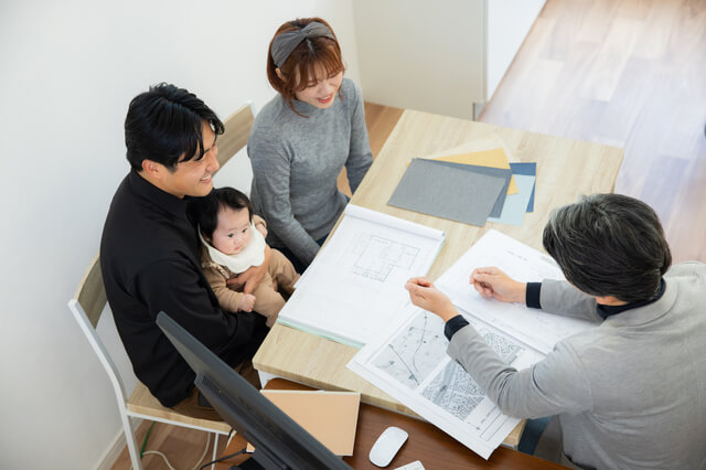 家づくりについて相談する夫婦と子ども