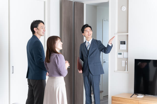 中古住宅について説明する男性と夫婦