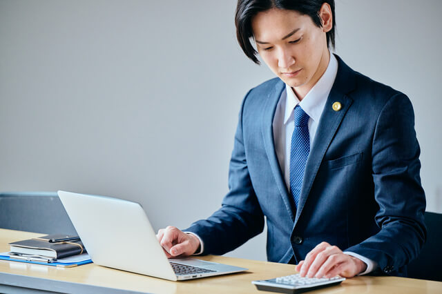 電卓で計算するビジネスマン