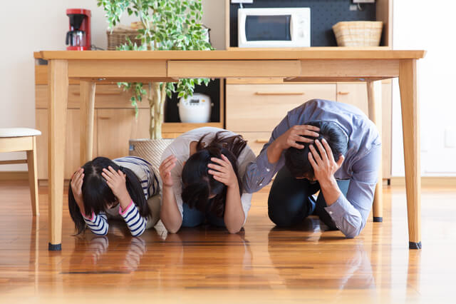 机の下に避難する家族