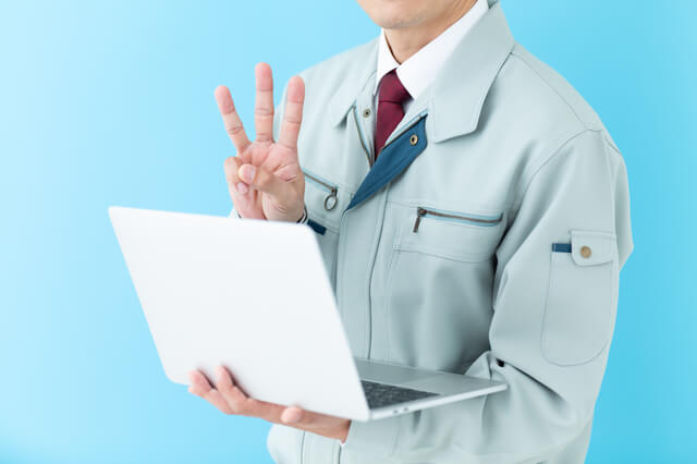 3本指を立てる男性