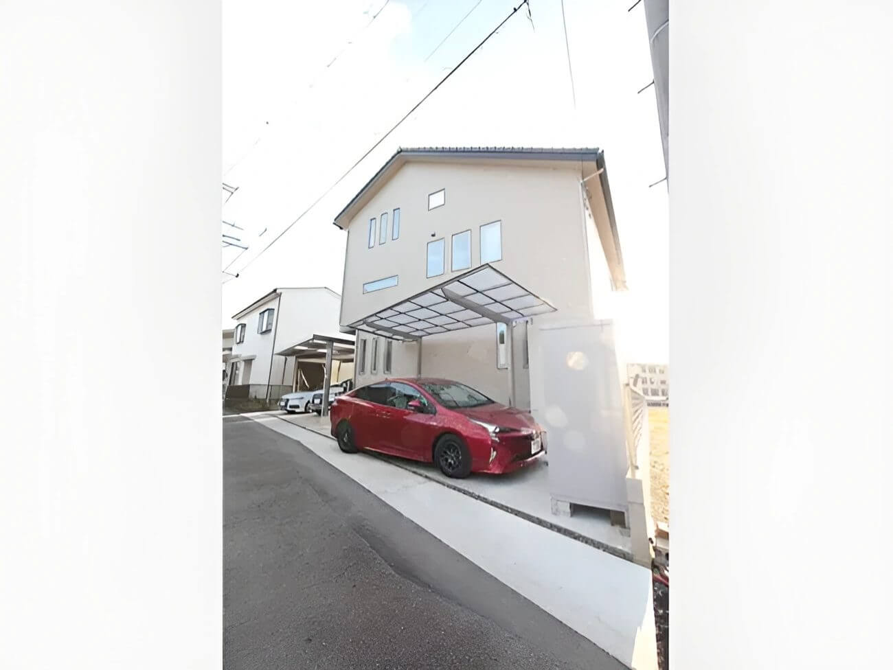 傾斜地に建築された白を基調として住宅