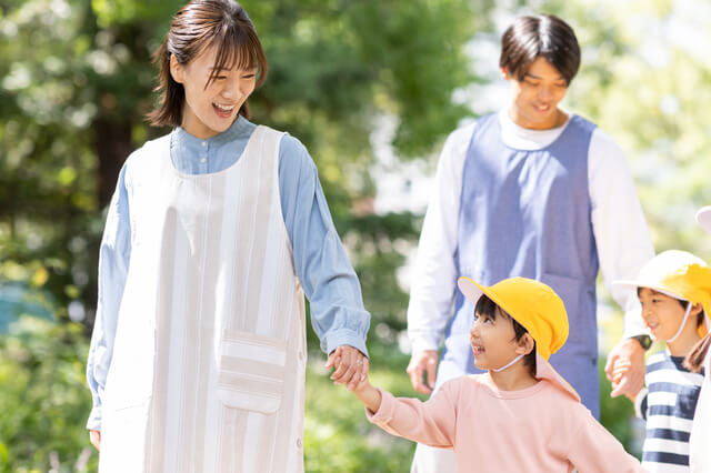 公園を散歩する保育士